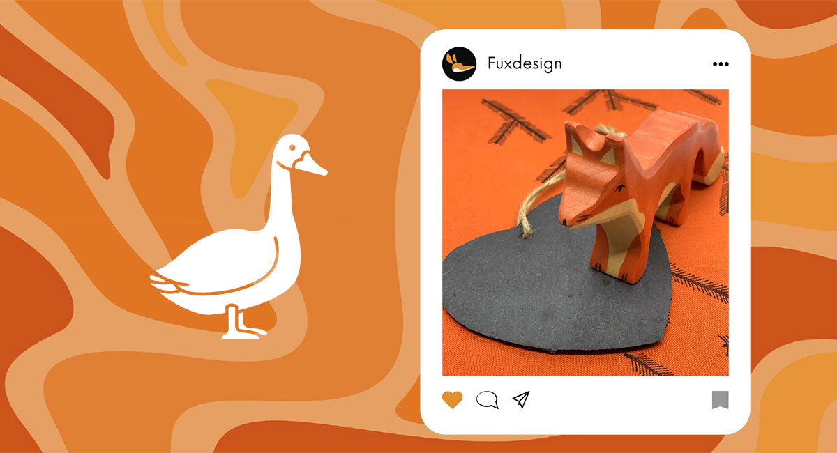 Fuxdesign, Christiane Wilke, Illustration, orangener Hintergrund, darauf eine weiß Gans, ei Fux aus Holz steht auf einem Schieferherz und schaut zur Bildmitte